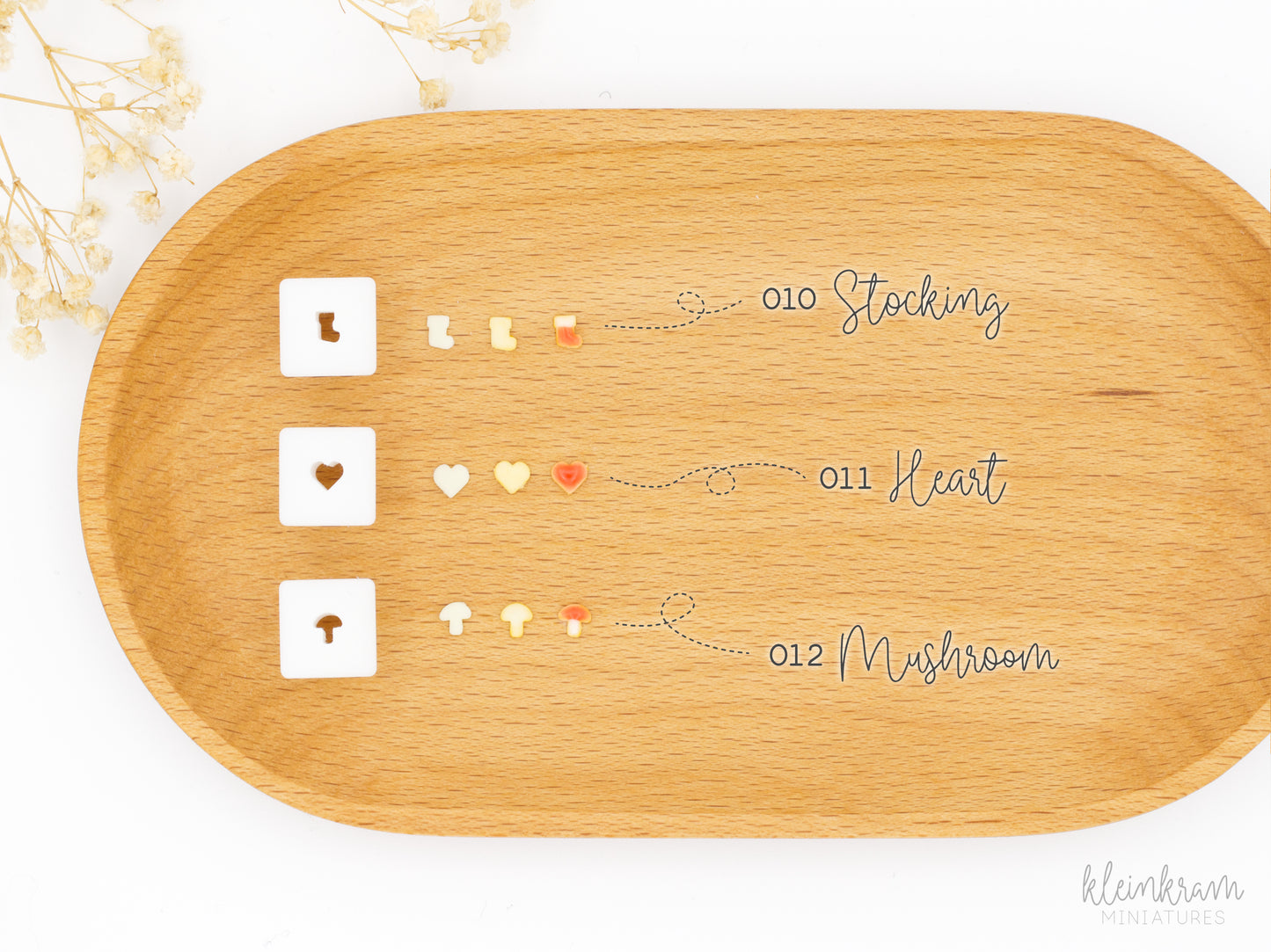 Three small square 1:12 scale clay cutters displayed next to the clay shapes they produce: a stocking, a heart, and a mushroom.